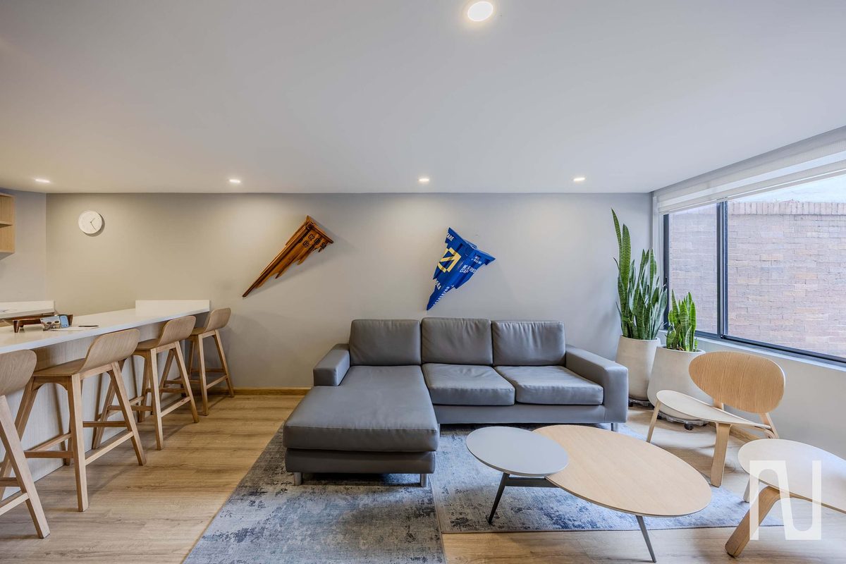 Living room with L-shaped sofa, breakfast bar and large windows