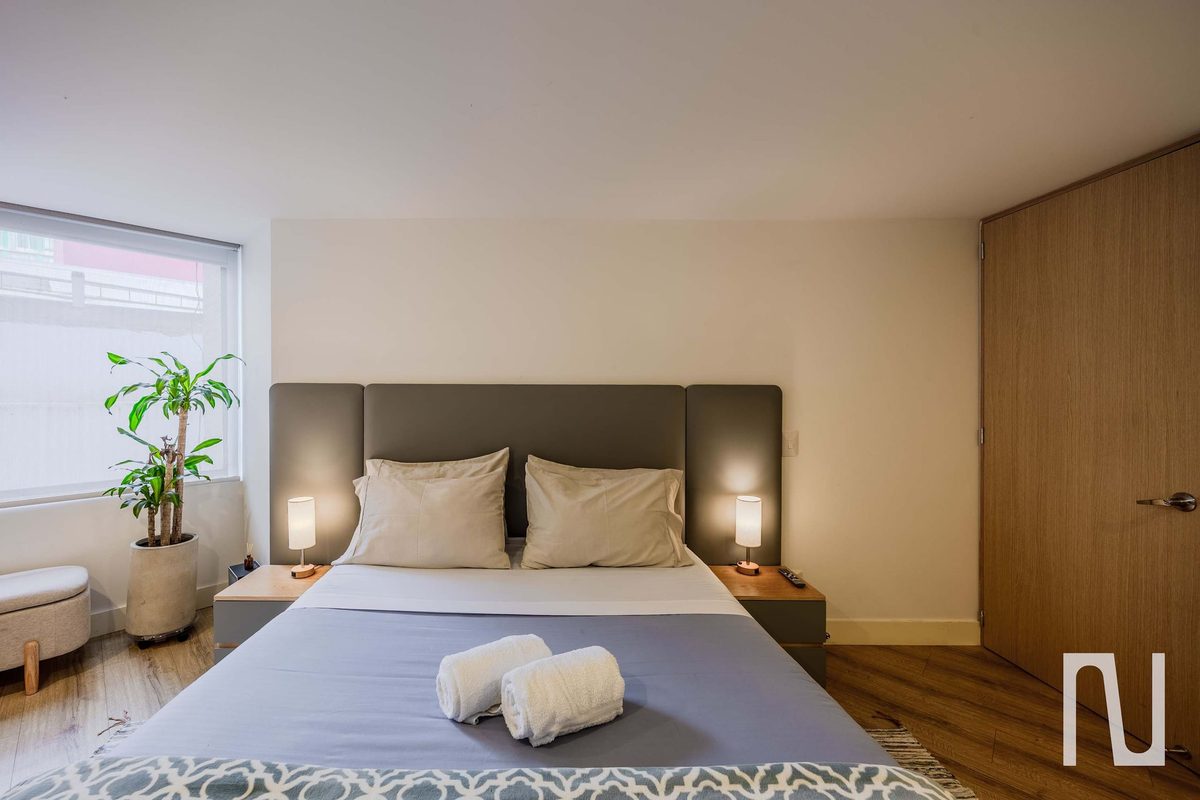 Bedroom 1 with double bed and bedside lamps